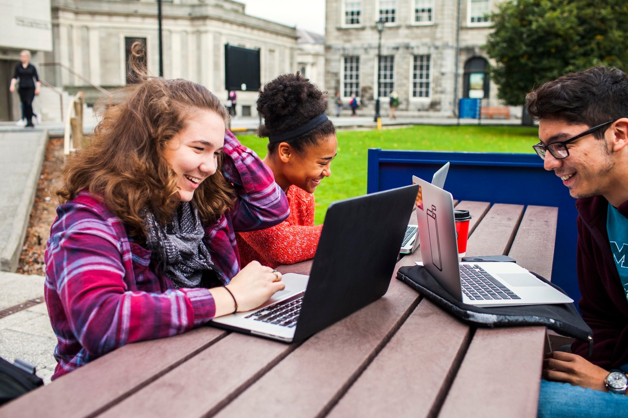 smiling-university-students-with-laptops-on-table-2026-01-05-05-01-36-utc
